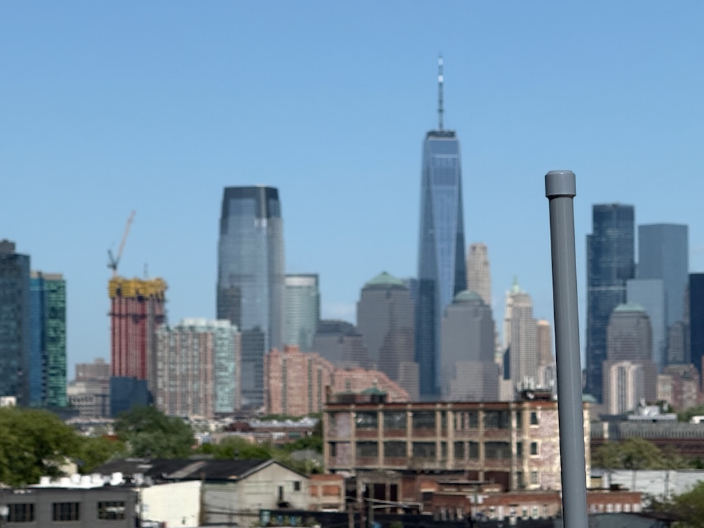 Grey antenna in front of the downtown Jersey City and Lower Manhattan skyline.